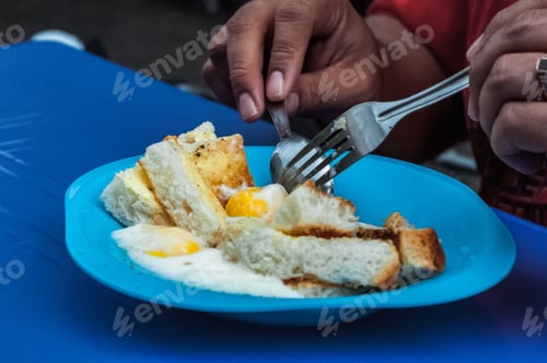 Preview: eating roti telur goyang, malaysian breakfast of half cooked egg with white toasted bread