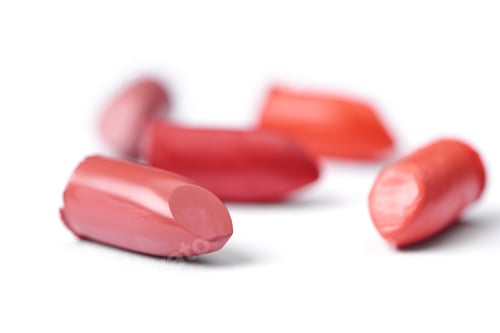 Preview: close up view of cut lipsticks on different colors on white backdrop
