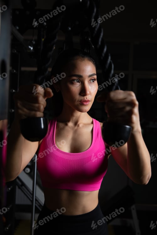 Preview: Focused Woman Performing Rope Tricep Extension in Gym