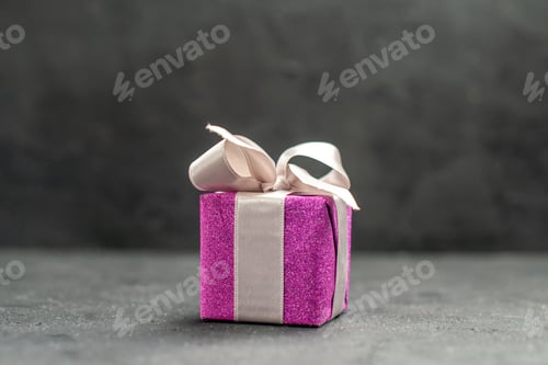Vista previa: top view pink giftbox with white ribbon on dark isolated background free space