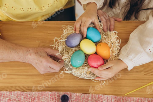 Preview: Happy easter! A grandmother and her granddaughter painting Easter eggs