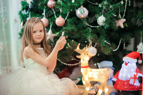 Preview: Little cute girl near christmas tree. Children under Christmas tree with gift boxes
