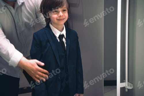 Preview: Smiling boy and his father trying school uniform for future schooler.