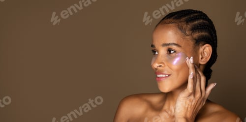 Preview: Portrait of black middle aged woman wearing under eye patches, taking care of her skin, brown