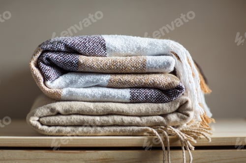 Preview: home textile. stack of beige wool blankets on a wooden shelf.