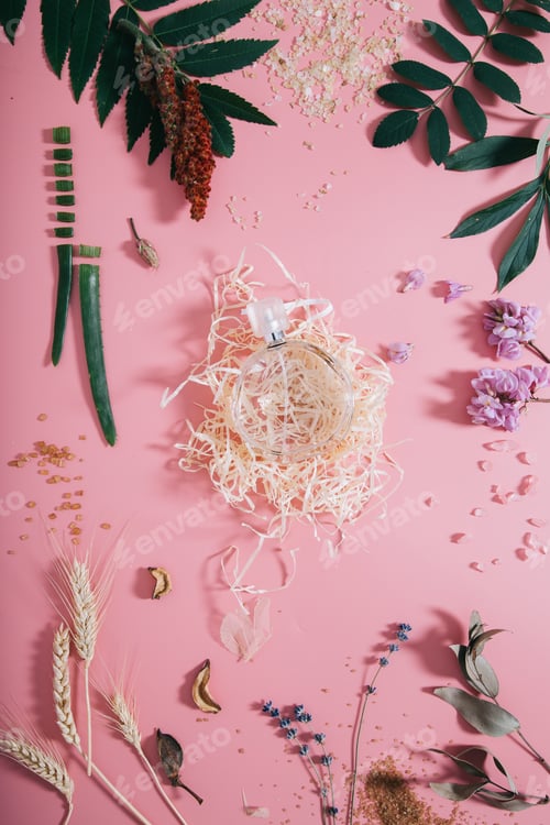 Preview: Creative flat lay top view of perfume mock up on pastel millennial pink paper background.