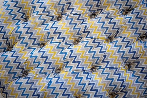 Preview: Close up of mottled soft sofa texture with sunken buttons.