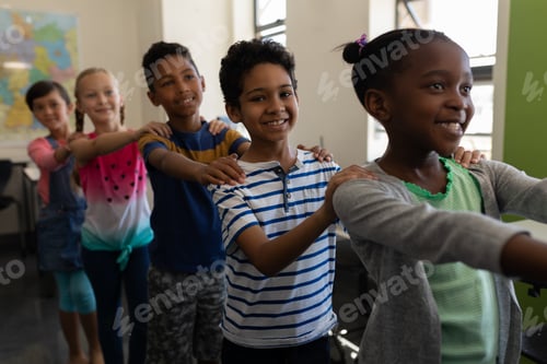 Preview: School kids standing in row with their hands on shoulder in classroom of elementary school