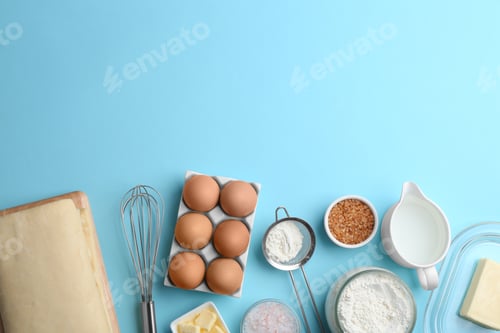 Preview: Puff pastry dough and ingredients on light blue background, flat lay. Space for text