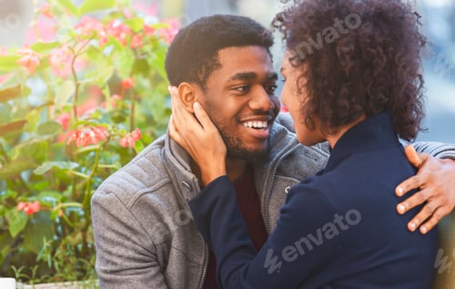 Preview: Afro couple in love telling each other sweet words, hugging