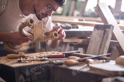 Preview: male carpenter working with a wood product, hand tools