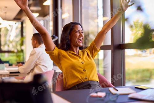Preview: Excited Mature Businesswoman Celebrating Working At Desk In Office