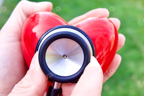 Preview: Nurse holding a stethoscope up to a red heart