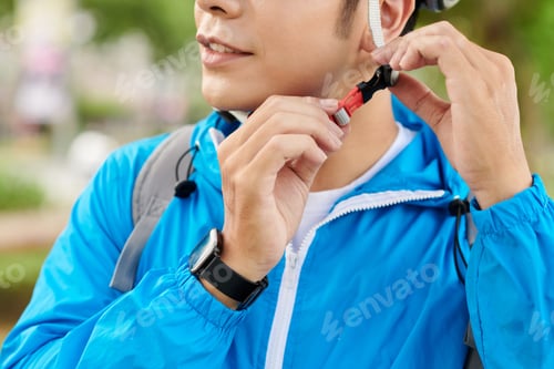 Preview: Cyclist Putting on Bicycle Helmet