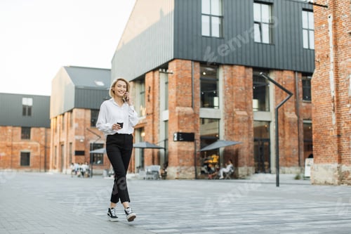 Preview: Business woman in white shirt talking on smartphone.