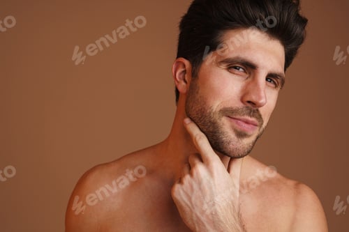Preview: Pleased half-naked man looking at camera and rubbing his face