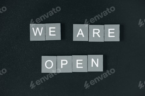 Preview: We are open quote, welcome sign for business or caffe, wooden letters on black background