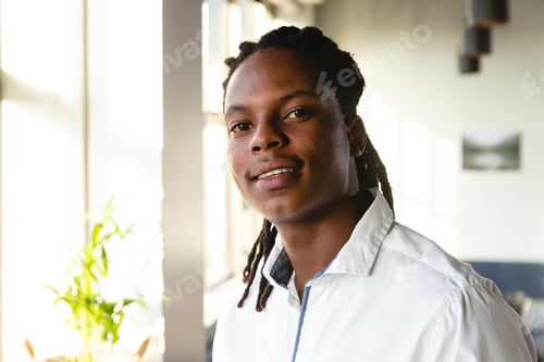 Preview: Portrait of confident african american young businessman with dreadlocks in creative office