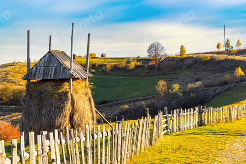 Preview: Haystack under wooden roof built behind fence in highland