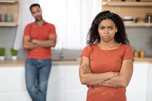 Preview: Offended sad unhappy millennial black woman in red t-shirt ignores husband after quarrel in kitchen