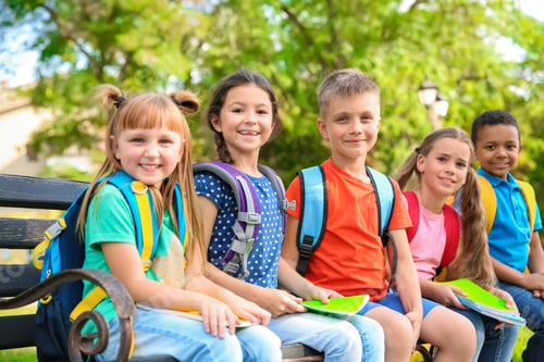Preview: Cute little children with backpacks and notebooks outdoors. Elementary school