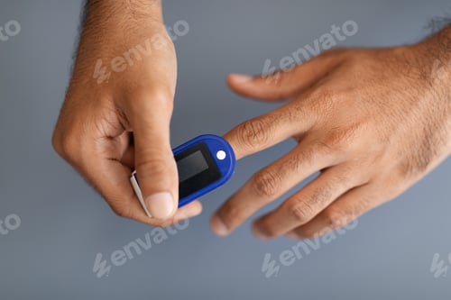 Preview: Unrecognizable man using pulse oximeter, grey background