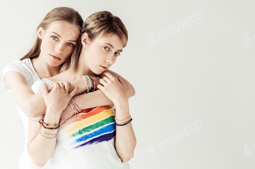 Preview: Woman hugging her girlfriend from the back and looking at camera isolated on white