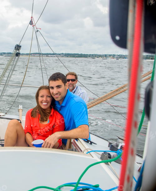 Preview: Couple relaxing on sailboat, looking at camera smiling