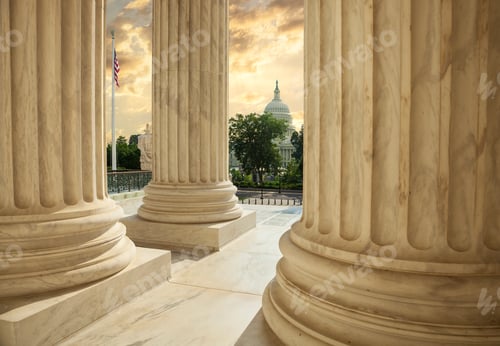 Preview: United States Capitol Building viewed between columns of the Supreme Court at sunset