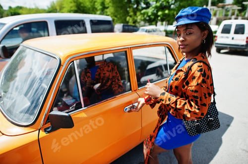 Preview: African american lady near orange classic retro car
