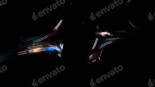 Preview: Aerial view of a roundabout road at night with long exposure neon car lights illuminating the dark