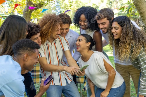 Preview: A joyful group of friends gathers closely, laughing and sharing something on their phones