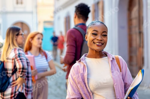 Preview: Portrait of smiling African American female student with friends looking at camera.