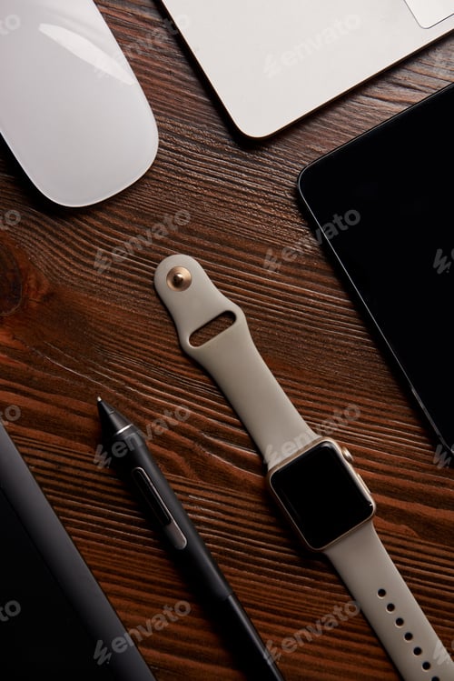Preview: top view of smart watch with various gadgets on wooden table