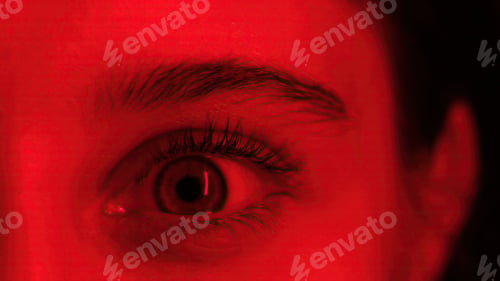Preview: Young Girl Opens Wide Her Large Eye In Red Light, Close Up View