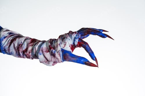Preview: A blue witch hand with red nails,wrapped blood-stained bandage against white background.This eerie