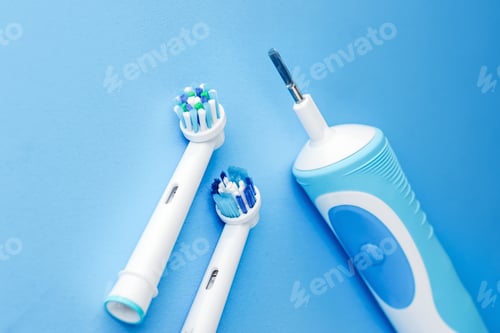Preview: Modern electric toothbrush and spare heads on blue background