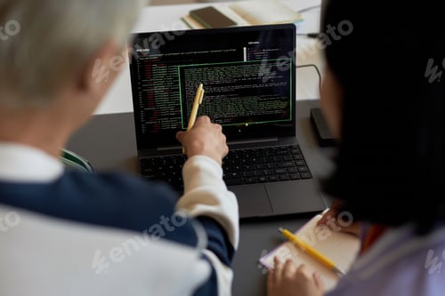 Preview: Guy with pen pointing at codes on laptop screen during presentation