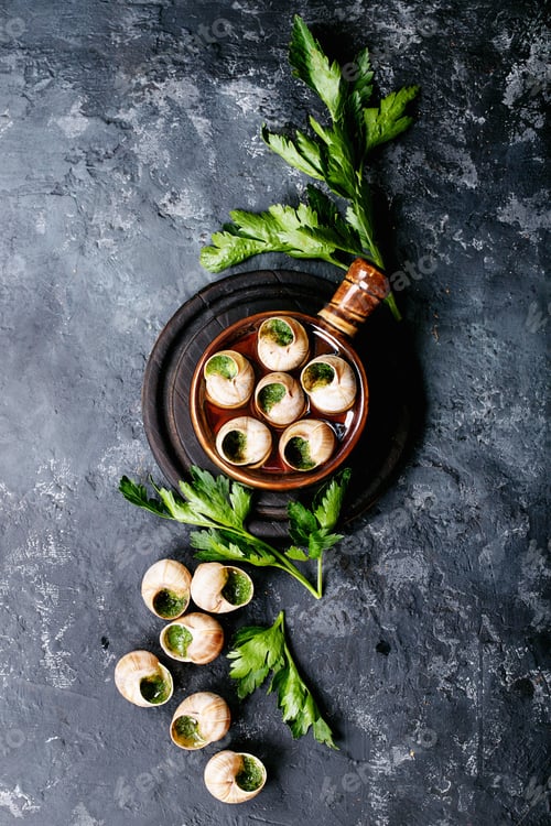 Preview: Baked snails with garlic butter and fresh herbs in a frying pan, selective focus
