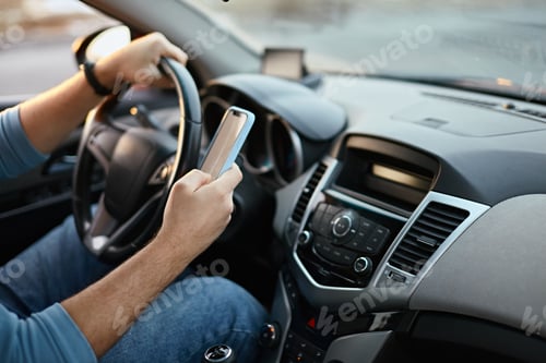 Preview: Hands of unrecognizable man driver using mobile phone while driving