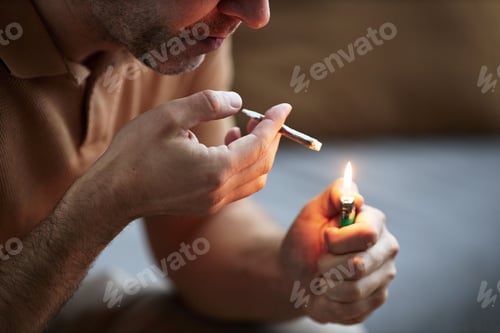 Preview: Unrecognizable adult man lighting up cigarette smoking for therapeutic purpose