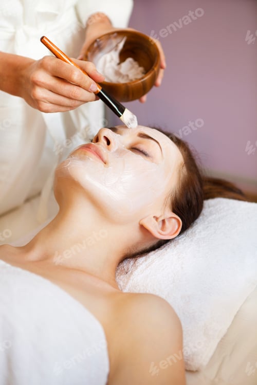 Preview: Young beautiful woman in a mask for the face of the therapeutic white mud