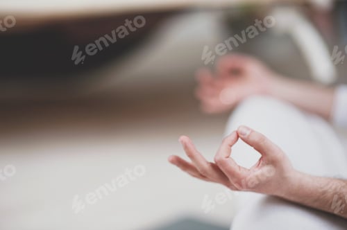 Preview: Candid authentic man millennial sitting in lotus pose and doing yoga in studio at home