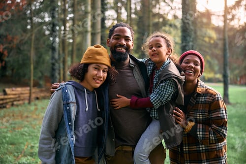 Vista previa: Happy black family enjoying in camping weekend in the woods and looking at camera.