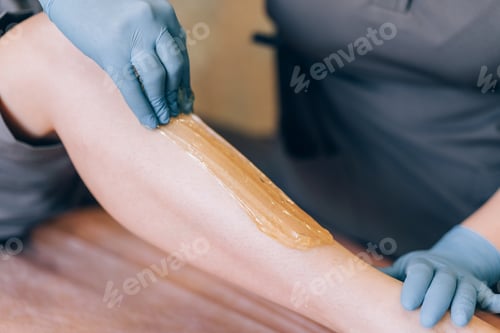 Preview: The specialist depilates the hair with shugaring on the leg
