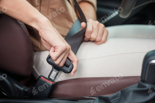 Preview: woman driver hand fastening seat belt during sitting inside a car and driving in the road. safety,