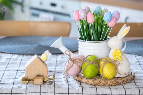Preview: Key to house of cozy home with Easter decor with rabbit and eggs on table
