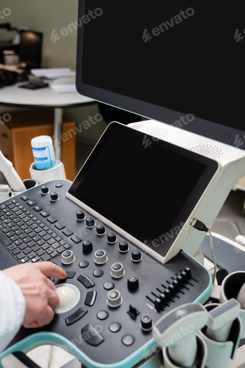 Preview: partial view of doctor operating modern ultrasound machine with large monitors