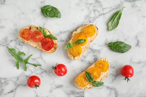 Preview: Delicious tomato bruschettas on white marble background, flat lay