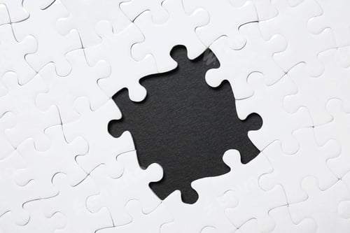 Preview: Frame made with white puzzle pieces on black background, top view. Space for text